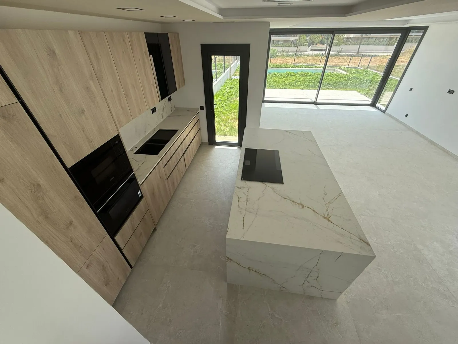 La cocina, con el jardín y la piscina delante